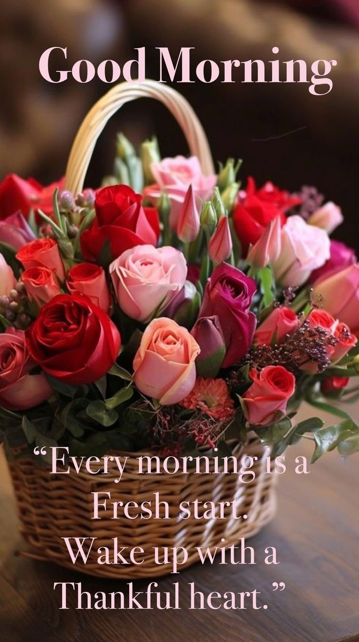 This may contain a basket filled with roses sitting on top of a table next to a sign that says good morning
