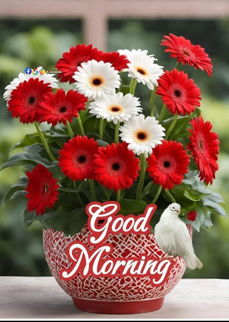 This may contain a vase filled with red and white flowers next to a bird on top of it